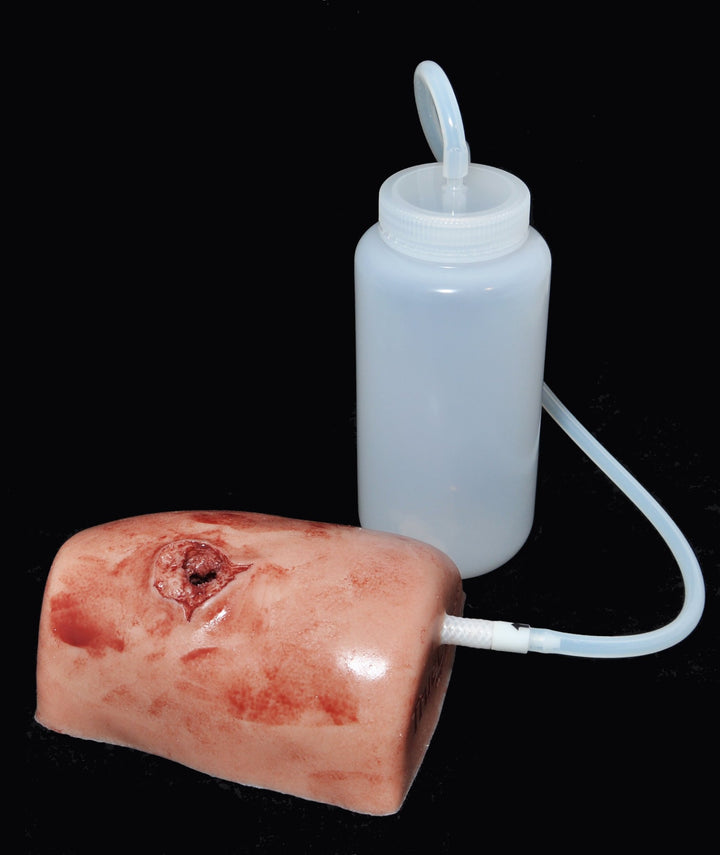 TrueClot wound trainer and bottle setup shown on black background to highlight realism of simulated wound.