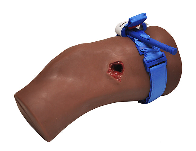 TrueClot dark-skin-toned PCT3 Task Trainer featuring a tourniquet applied above simulated trauma wound.
