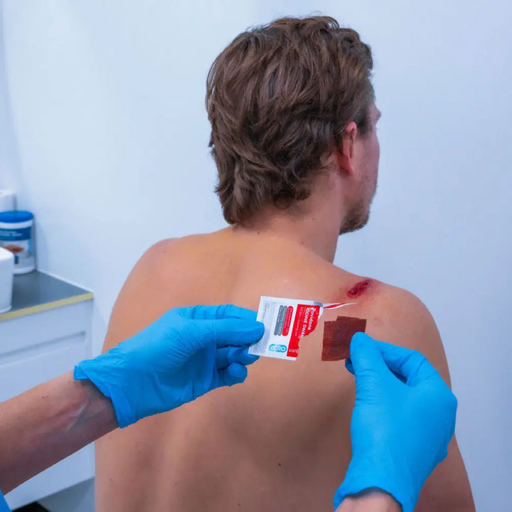 First responder applying iodine swab to patient's back prior to injection