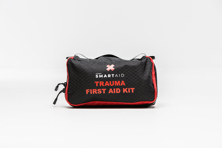 Black vehicle trauma kit with red trim and white text reading 'TRAUMA FIRST AID KIT' on the front.