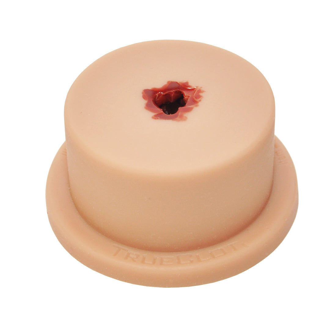 TrueClot Basic Packing Trainer showing simulated wound cavity on a round flesh-toned base.