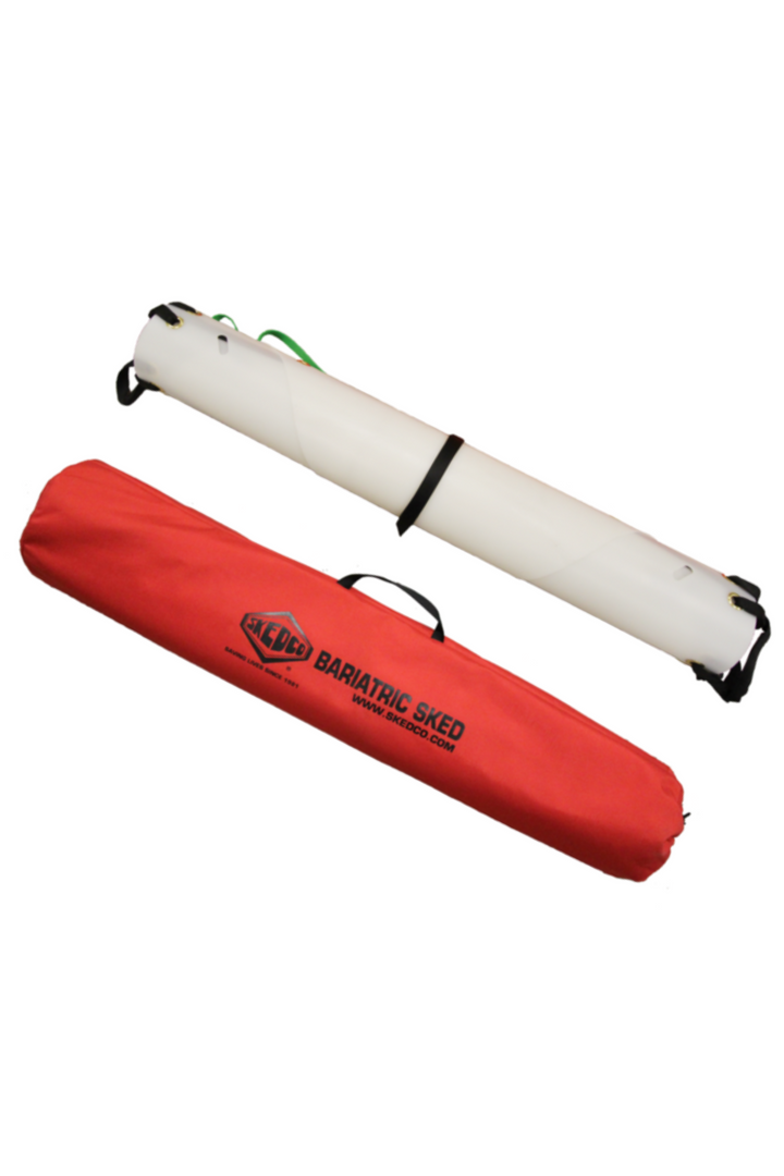 The image shows a Bariatric Sked® Stretcher rolled and stored in a red carrying bag with black handles. The bag features the Skedco Bariatric Sked logo in black, with green and black straps visible, set against a plain white background. Designed for obese patient rescue.