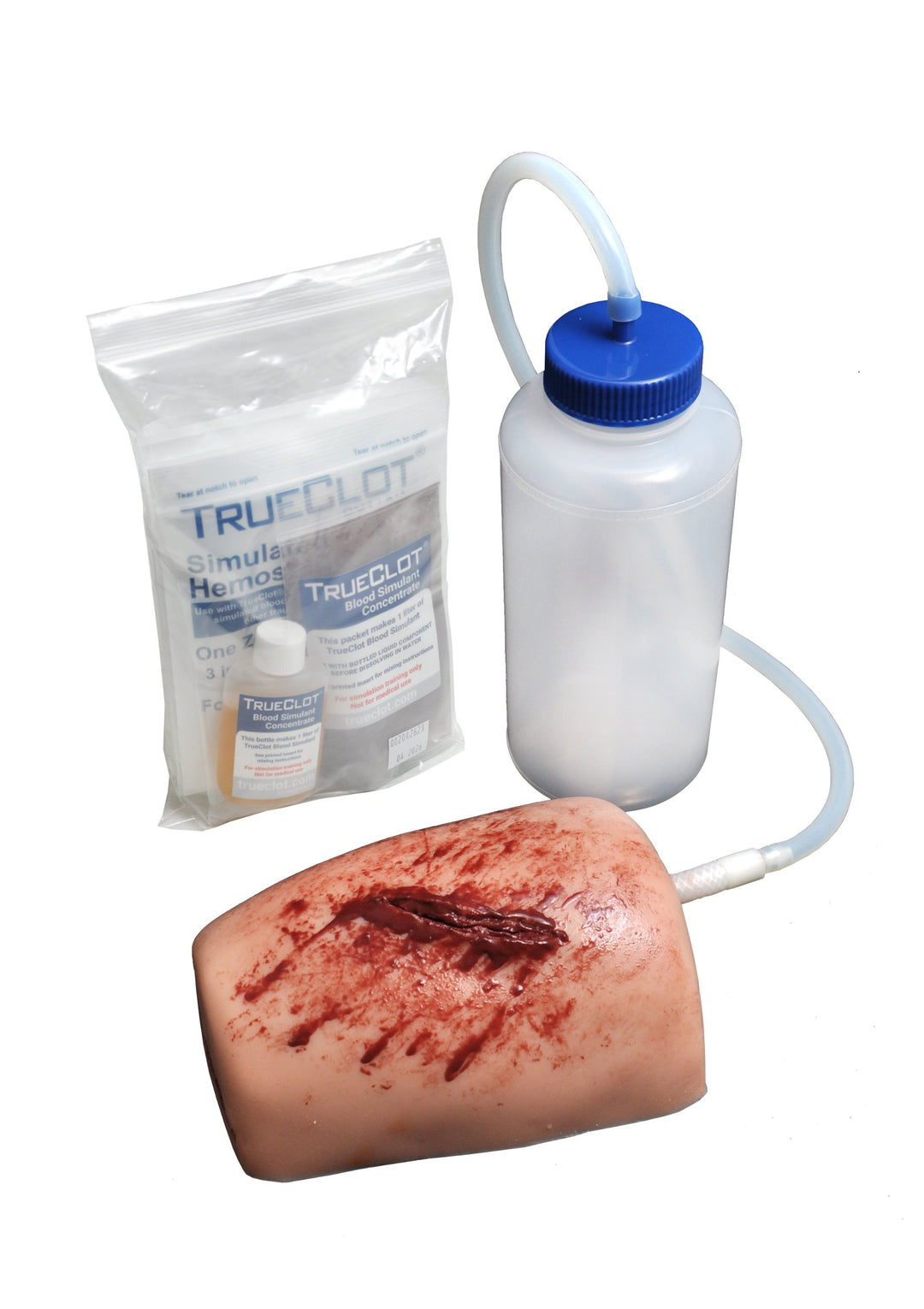 TrueClot Wound Packing Task Trainer kit including simulated wound block, fluid bottle with tubing, and simulated blood supplies.