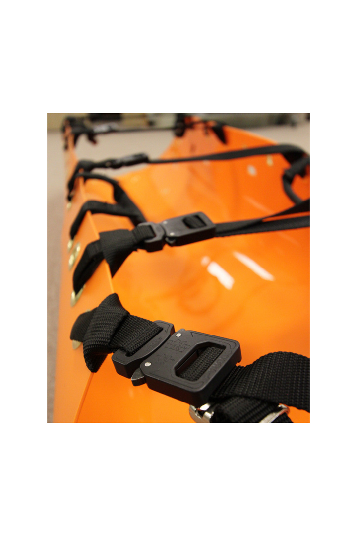 The image shows the SKED-EVAC® Aluminum Side Release Buckle Conversion Kit in use