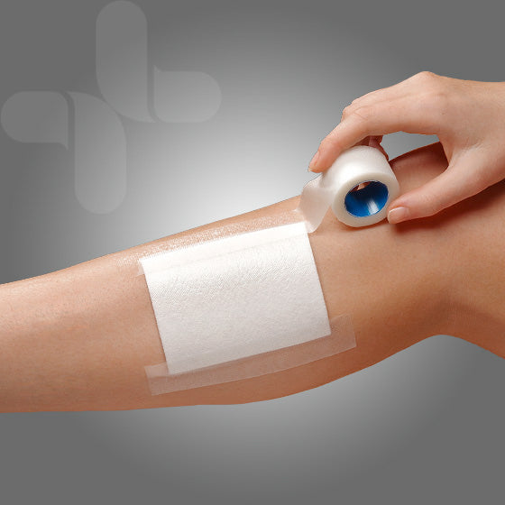 Close-up of a hand applying AeroPlast transparent tape over a bandage on a forearm.