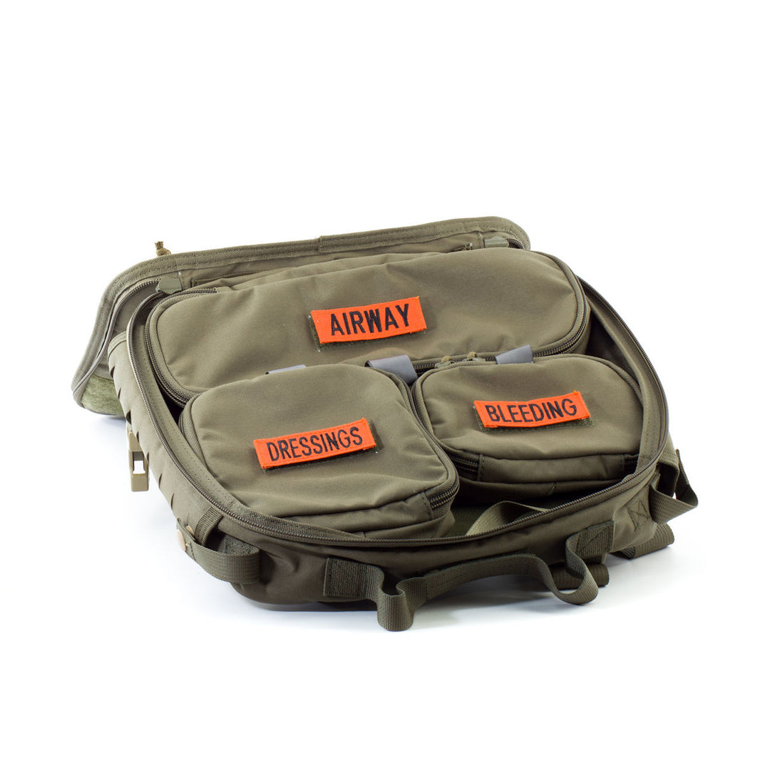 Internal view of the bag with modular pouches laid out and labeled for different injury types.