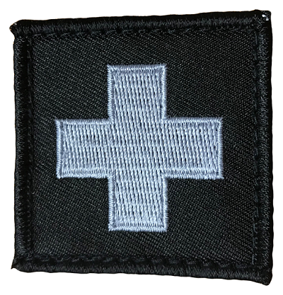 TacMed Medic Patch featuring a grey embroidered medical cross on a black tactical background. Sized 50mm x 50mm with hook backing for easy attachment. TacMed Australia – discreet identifier for medics and first aid pouches.