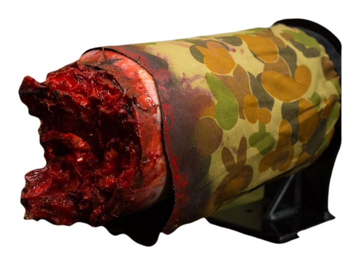 Realistic bleeding leg wound simulator with camo wrap for emergency tourniquet training.