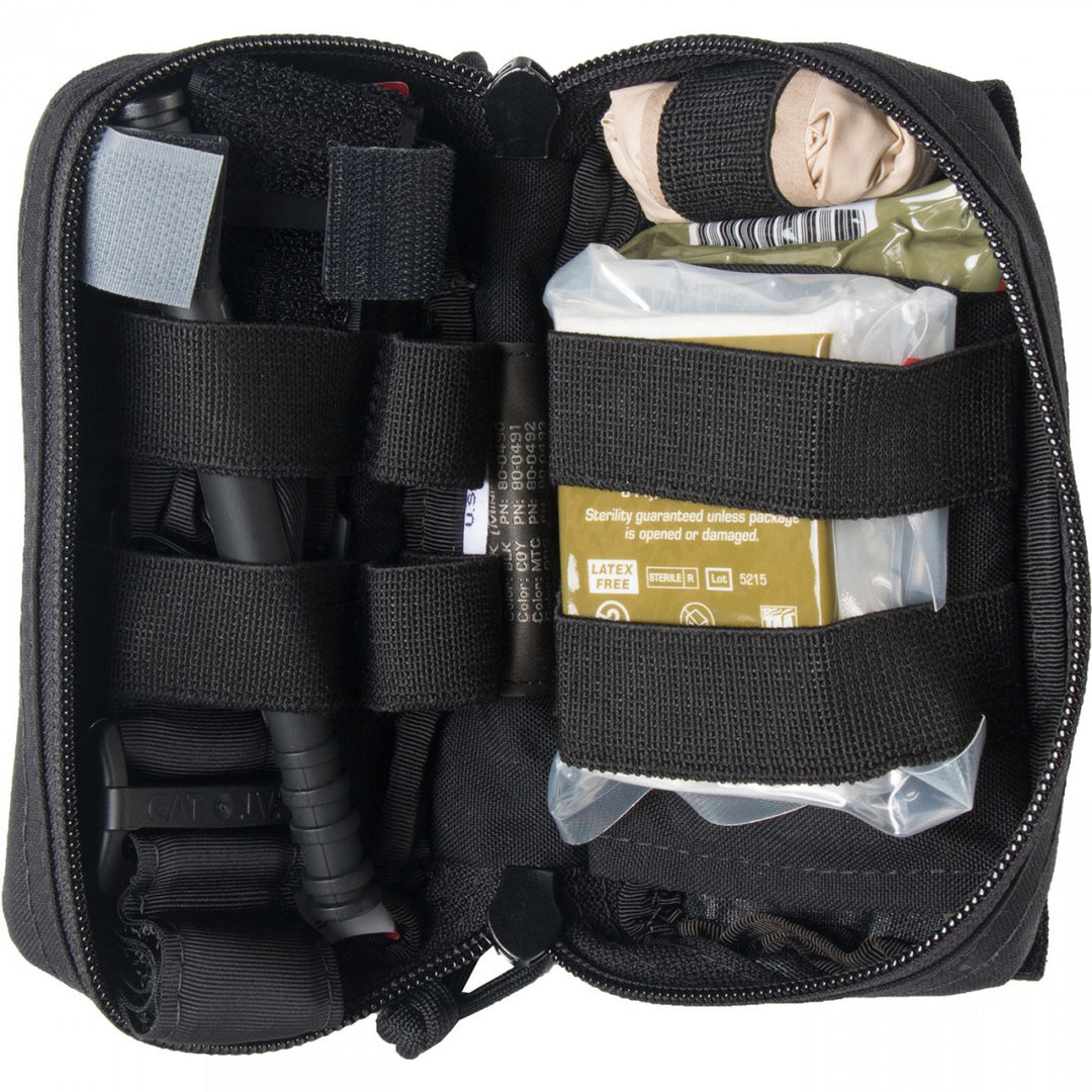 Interior view of M-FAK showing packed trauma supplies including bandages and medical tools secured with elastic straps.