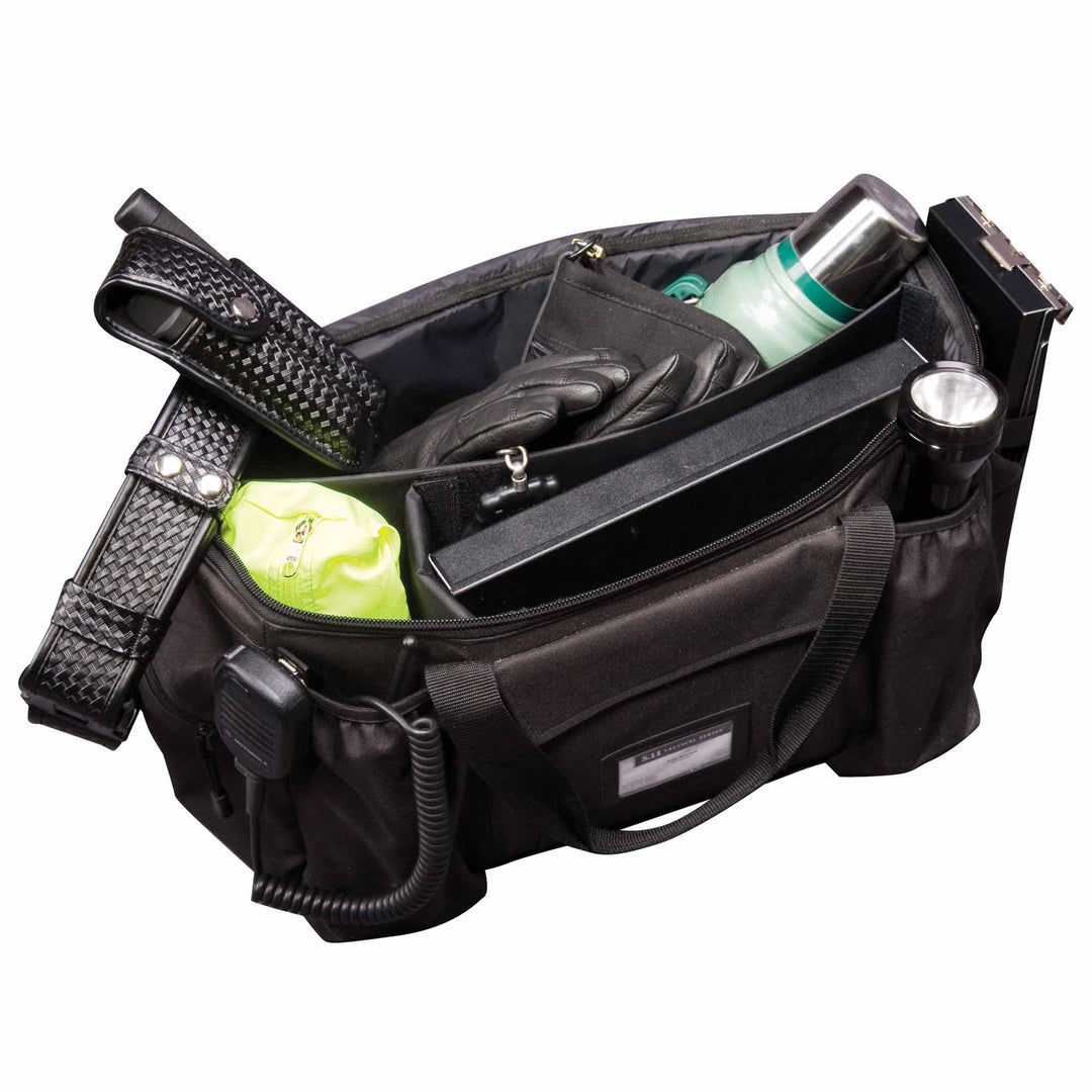 Top-down view of patrol bag opened to reveal medical gear, water bottle, and tactical supplies.