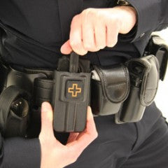 Law enforcement officer attaching Eleven 10 RIGID TQ Case to duty belt. Engineered for quick access under pressure. TacMed Australia – field-tested gear for rapid tourniquet deployment.