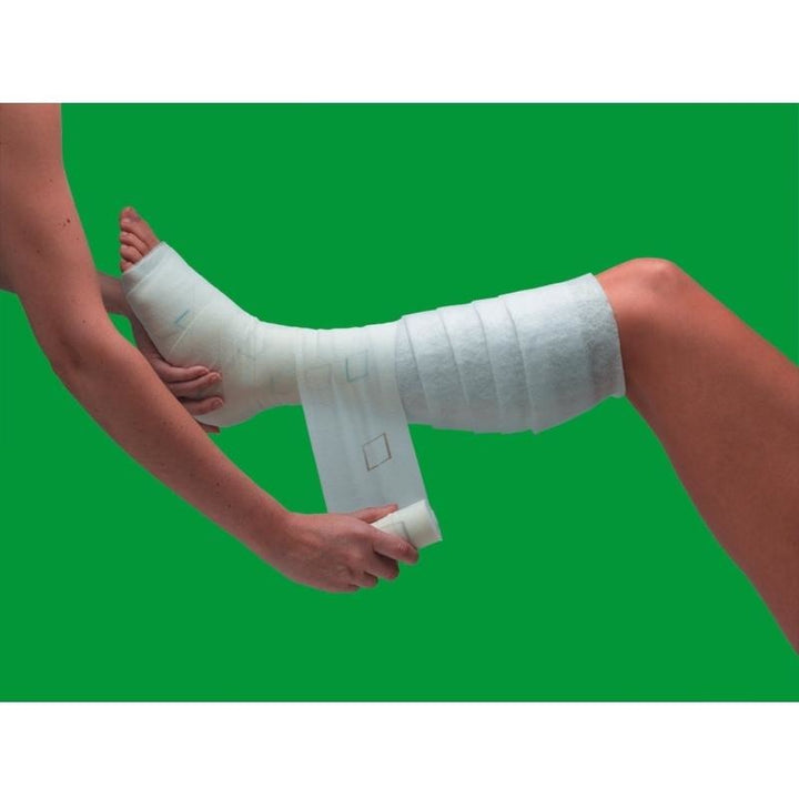 Setopress bandage being applied to patient’s lower leg with graduated pressure. Provides consistent high compression for wound care. TacMed Australia – professional dressing for venous insufficiency management.
