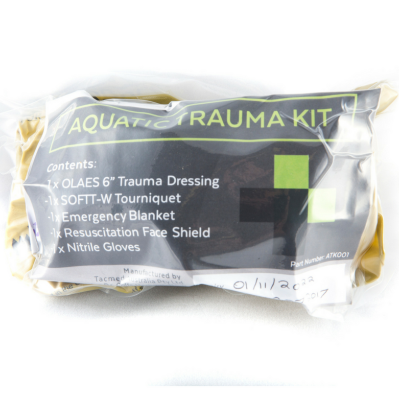 Vacuum-sealed Aquatic Trauma Kit showing label listing contents including trauma dressing, tourniquet, emergency blanket, face shield, and gloves.