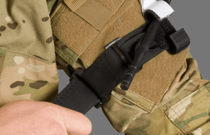 CAT Tourniquet in black applied to arm over tactical uniform in a field scenario. Built for use in military trauma care and self-application under pressure. TacMed Australia – reliable tourniquets for operational responders.