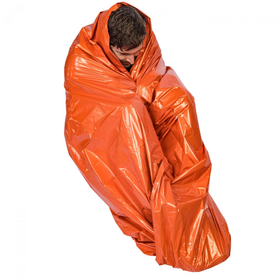 Person wrapped in a reflective, high-visibility orange emergency survival wrap for warmth and protection.