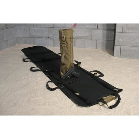 Foxtrot litter deployed on sandy ground with tan storage bag attached.