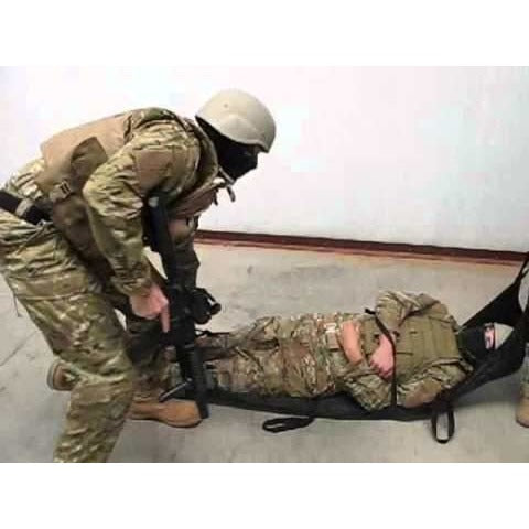 Two tactical medics using the Phantom Litter to carry a casualty indoors.