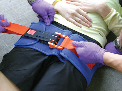 First responders applying the SAM Pelvic Sling to a patient’s hips for pelvic stabilization.
