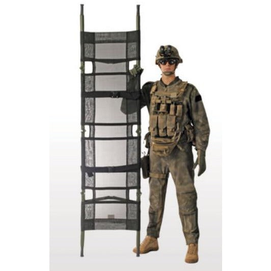 Person in military uniform standing beside an upright Talon II stretcher, demonstrating its full vertical height and folded structure.