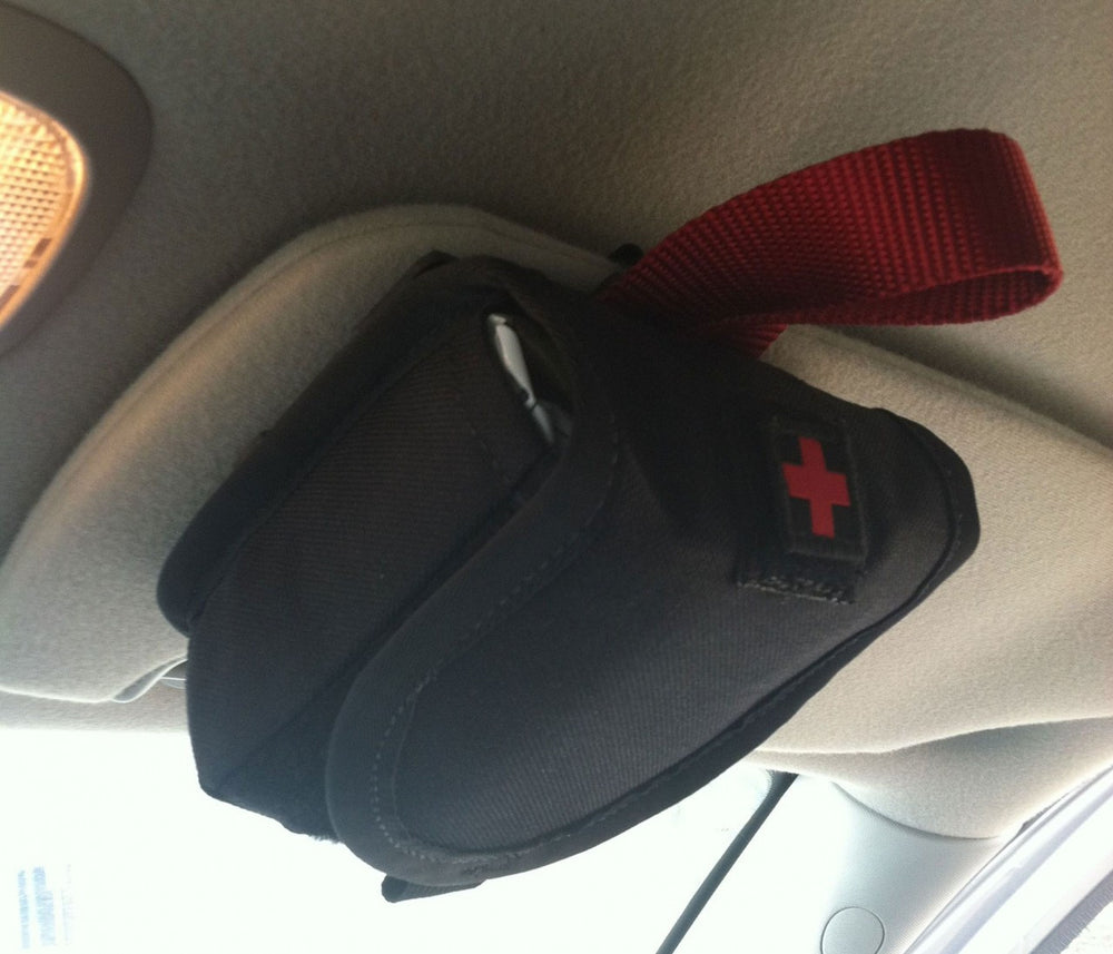 MOLLE pouch attached to a car sun visor using the Eleven10 visor mount with visible orange pull tab.