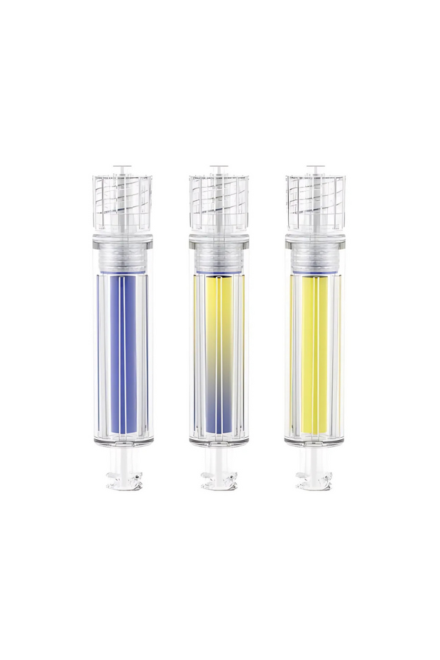 The image displays three transparent cylindrical medical devices, likely syringes or vials, arranged side by side against a white background. Each device has a colored liquid inside: the left one contains a purple liquid, the middle one a gradient from purple to yellow, and the right one a yellow liquid. The devices have a ribbed texture and a clear cap at the top, suggesting they are designed for medical use.