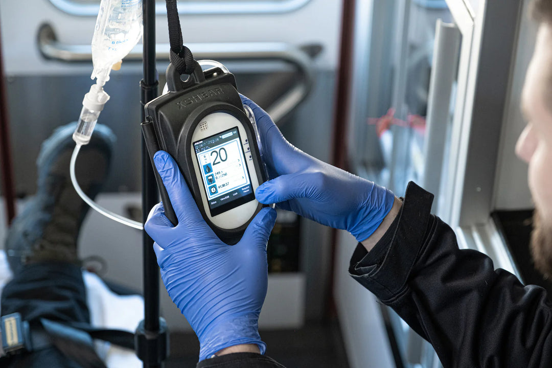IV pump secured in vehicle with XShear case attached to IV pole

