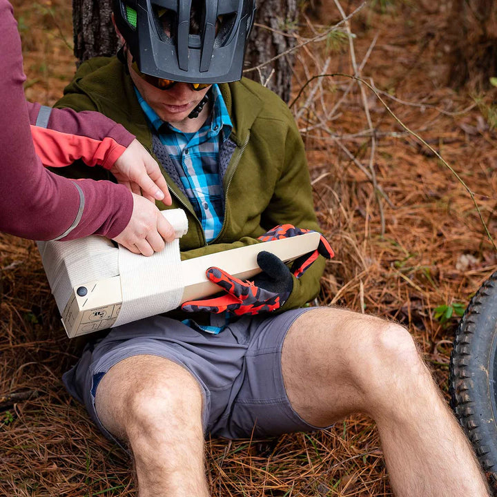 Responder applying RISE splint to lower leg in outdoor setting

