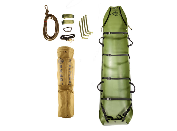 Complete Sked Basic Rescue System kit including green stretcher, rope, straps, and storage bag laid out vertically.