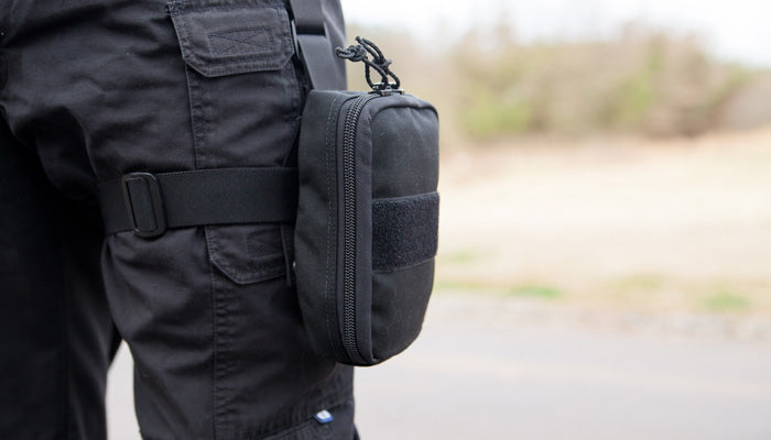 Black LAPD trauma kit pouch securely mounted on a user's thigh over tactical pants.